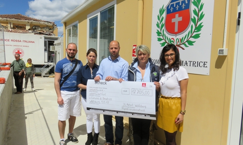 Die Wolfsburger Delegation übergibt den Spendencheck (v.l. Marcello Aiello, Esra Erkan, Christian Matzedda, die Vizebürgermeisterin Patrizia Catenacci von Amatrice und Burcu Akcali. Im Hintergrund ist eines der stark beschädigten Häuser zu sehen. Fotos: IG Metall