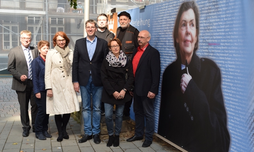 Oberbürgermeister Dr. Oliver Junk, Sponsoren und Unterstützer freuen
sich über das Ergebnis: Kaiserringträgerin Isa Genzken blickt nun vom Bauzaun am
historischen Rathaus Richtung Marktstraße/Hoher Weg. Foto: Stadt Goslar