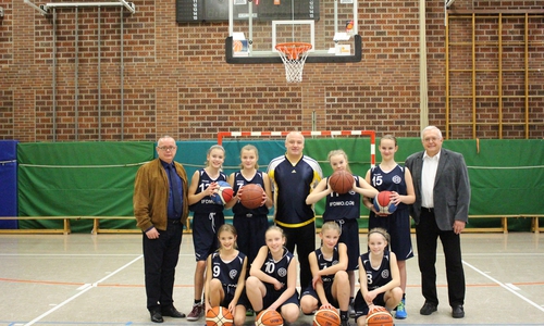 Die U-13 Mädchenmannschaft sowie der Trainer Thorsten Weinhold (Mitte) freuen sich über die gespendeten Basketbälle des Fördervereins. Hier vertreten durch den stellvertretenden Vorsitzenden Andreas Meißler (links) und dem Vorsitzenden Klaus Hantelmann (rechts). Foto/Video: Max Förster