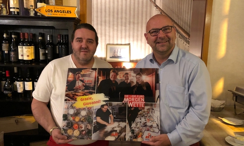 Giovanni wird von Marc Angerstein im Auftrag von 89.0 RTL mit einer Foto-Collage zu einer gemeinsamen Radiowette überrascht. Foto: Werner Heise