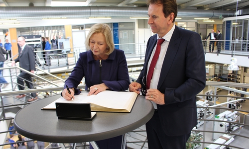 Bundesbildungsministerin Prof. Dr. Johanna Wanka trägt sich nach der Begrüßung durch Dr. Karlheinz Blessing in das Gästebuch von Volkswagen ein. Foto: Christoph Böttcher