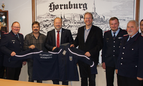Eingerahmt von den Mitgliedern des Ortskommandos werden Bernd Reiner, Matthias Peter und Dr. Jörg Vietmeier bei der offiziellen Übergabe. Foto: Freiwillige Feuerwehr Hornburg
