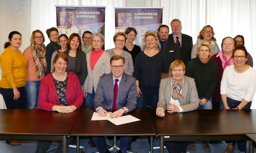 Landrat Dr. Andreas Ebel unterzeichnet eine Richtlinie, mit der der Landkreis Gifhorn die Ansiedlung freiberuflicher Hebammen und Entbindungspfleger unterstützen möchte; (vorne links im Bild: Stefanie Winter, Kreisvorsitzende Gifhorn, Hebammenverband Niedersachsen e.V., vorne rechts im Bild: Christine Gehrmann, Leiterin der Stabsstelle Demografie). Foto: Landkreis Gifhorn