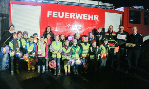 Peter Lubnow (2.v.r.) überraschte die Kinderfeuerwehr nach dem Laternenumzug mit einem Scheck und einem Spiel. Fotos: Werner Heise