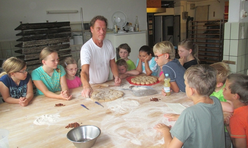 Biobäcker Stefan Barth  erklärt wie runde und eckige Brötchen geformt werden. Foto: privat