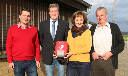 Manja Puschnerus und Martin Roßa (mitte) von der Curt Mast Jägermeister Stiftung übergeben den Automatisch Externen Defibrillator an Dirk Meier (l.) und Hans-Hermann Leiste vom FC Arminia Adersheim. Foto: Werner Heise