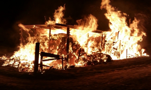 Der brennende Holzunterstand am Sportplatz, in dem Eichenholz und Heuballen lagerten. Foto: FF Sickte