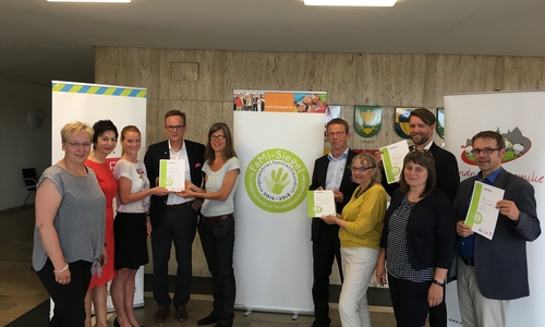 Stadt Wolfsburg, IHK Lüneburg-Wolfsburg, NEULAND Wohnungsgesellschaft mbH und Ev. Familienbildungsstätte bekommen das Fami-Siegel verliehen. Foto: Stadt Wolfsburg