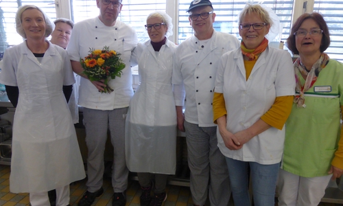 Der „20-jährige-Dienstjubilar“ Frank Hahne mit Blumenpräsent im Kreise seiner Kolleg*innen in der SchloßkücheFoto: Sabine Resch-Hoppstock