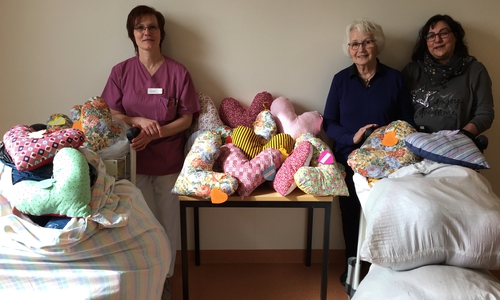 Breast care nurse Anette Hoge (links) nahm die 105 Herzkissen von den Jembker Landfrauen Rosemarie von Wahl und Beate Tombers dankend entgegen. Foto: Helios