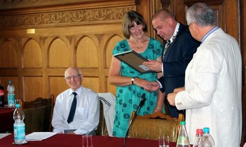 Collette Boyle erhält die Ehrungs-Urkunde für ihr bürgerschaftliches Engagement stellvertretend für den Bürgermeister von Chard aus den Händen von Helmstedts Bürgermeister Wittich Schobert. Fotos: Stadt Helmstedt