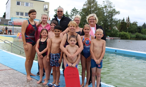 Von links: Die Schwimmtrainerinnen Anne Boczaga und Alicia Eßer, der WSV-Vorsitzende Rainer Porath, Schwimmmeisterin Pia-Maren Jaschiniak und Anja Kröger, 1. Vorsitzende des Wunschbaum e.V. sowie Sonja Fritz vom Jugendamt (vorne) freuen sich mit den Kindern. Foto: Max Förster