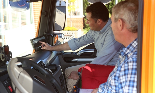 Bürgermeister Matthias Nerlich und Bauhofmitarbeiter Alexander Kunstmann erklären die Vorteile des Abbiegeassistenten. Auf dem Monitor erkennt der Fahrer einen Mann im toten Winkel. Foto: Michael Uhmeyer 
