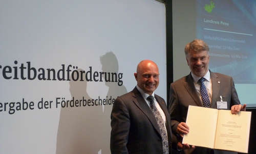 Kreisrat Henning Heiß nahm den Förderbescheid aus den Händen von Staatssekretär Rainer Bomba entgegen. Foto: Büro Heil