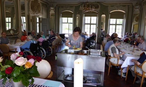 Therapeutin Ina Halbe beim Servieren des frischen Stangenspargels im Spiegelsaal der Seniorenbetreuung Schloß Schliestedt während des vom dortigen Heimbeirat initiierten „Tages der Heimbewohner“. Foto: privat