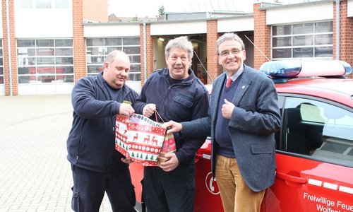 Die hauptamtlichen Feuerwehrmänner Carsten Franke (links) und Hans-Jürgen Fuhrmann, nehmen dankend die Präsente des Bürgermeisters Thomas Pink (rechts) an. Foto: Max Förster