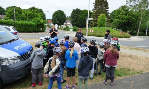 Henning Stremmel und Kathrin Lacey von der Polizei zeigen mit Lehrerin Livia Kapahnke (v.l.n.r.) der Klasse 4 b der Grundschule am Sonnenberg wie es richtig gemacht wird. Foto: Polizei