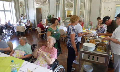Das Spargelessen mit dem Küchenteam und den Therapeutinnen im Spiegelsaal beim Servieren. Foto: Seniorenbetreuung Schloß Schliestedt
