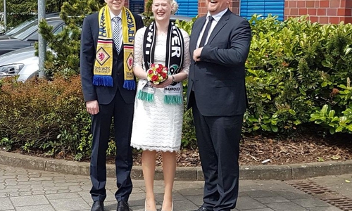 Nach der Trauung fanden sich die Brautleute stilecht mit Fanschals noch mit dem Bürgermeister zu einem Erinnerungsfoto zusammen. Foto: Stadt Lehre