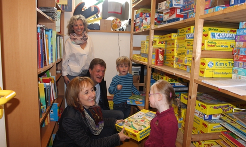 Erzieherin Kirstin Pöhl und Martin Roßa, sowie Manja Puschnerus mit Amelie und Theodor in der Spieleausleihe. Foto: Jan Borner