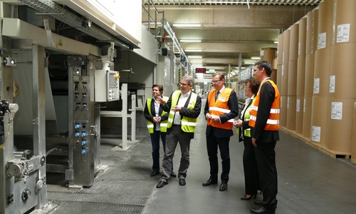 Der Geschäftsführer für Technik und Produktion der Firma Egger, Matthias Veile (2.v.l.), erläutert dem Landrat vor der Imprägnier-Anlage, wie Papier mit Harzen imprägniert und im Anschluss zu Schichtstoff verarbeitet wird. Fotos: Landkreis Gifhorn