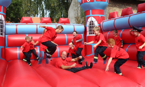 Kinderfeuerwehrwartin Cynthia Palic und stellvertretender Kinderfeuerwehrwart Andreas Glockentröger toben sich mit den Kids der Leinder Kinderfeuerwehr auf der Hüpfburg aus. Fotos: Jan Borner