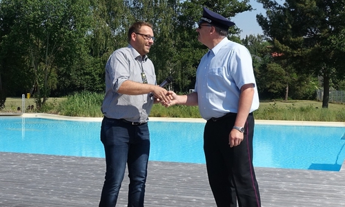 Samtgemeindebürgermeister Gero Janze übergibt die Ausweise zur kostenlosen Nutzung des Bades an Gemeindebrandmeister Maik Wermuth. Foto:  Samtgemeinde Grasleben