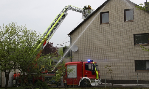 Um die Dachziegel zu entfernen, ist die Feuerwehr mit einem Leiterwagen im Einsatz. Foto: Rudolf Karliczek
