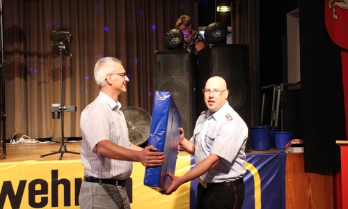 Uwe Berg von der Schladener VGH-Vertretung überreicht den mobilen Rauchverschluss. Foto: Freiwillige Feuerwehr Schladen