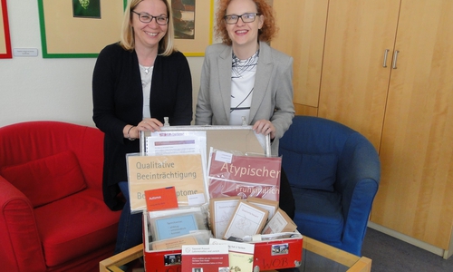Steffi Hamann (l.), Geschäftsführerin des Autismus-Therapie- und Beratungszentrum, zeigte Alexa von der Brelje, Sprecherin der Sparkasse Gifhorn-Wolfsburg, einen der prallgefüllten Lehrmittelkoffer. Foto: Sparkasse Gifhorn-Wolfsburg