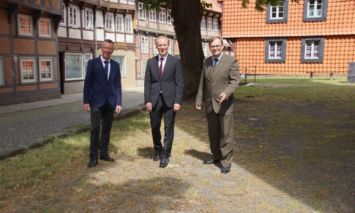 Die beiden Kirchenvorsteher Jörg Meyer (links) und Dr. Thomas Dahms (rechts) gehen gemeinsam mit Pfarrer Olaf Schäper (Mitte) auf dem „Steinweg“, dem ältesten dokumentierten und erhaltenen Pflasterweg der Stadt Hornburg um die Marienkirche. Foto: Gemeinde Hornburg