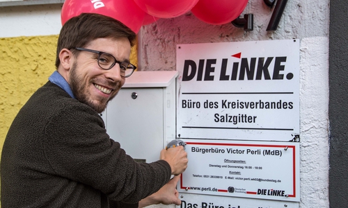Viktor Perli schraubt feierlich das Schild an das neue Bürgerbüro. Foto: Rudolf Karliczek