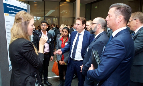 Dr. Karlheinz Blessing, Vorstand für Personal, Organisation und IT (in der Bildmitte), Stephan Wolf, stellvertretender Vorsitzender des Konzernbetriebsrats, und Thomas Schmall, Vorstand Konzern Komponente, im Gespräch mit der Doktorandin Barbara Theresia Wulfken. Foto: Volkswagen