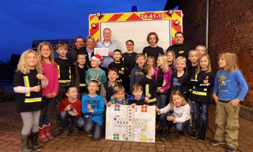Die kleinen Feuerdrachen und das Betreuerteam freuen sich über die Spende der Öffentlichen Versicherung Braunschweig, die Elmar Gahl überreichte (obere Reihe, Dritter von links.) Foto: Werner Gehrke