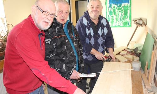 Roland Wolff, Ehrenamtlicher in der Lebenshilfe, bereitet mit den Bewohnern Rolf Busse und Eberhard Walter die Holzplatte zum Zuschnitt vor. Fotos: Privat