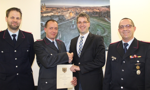 Oberbürgermeister Dr. Oliver Junk übergab die Ernennungsurkunde zum stellvertretenden Ortsbrandmeister an Dominik Dreilich. Holger Putz (links) und Stadtbrandmeister Christian Hellmeier nahmen an der Zeremonie teil. Foto: Anke Donner 