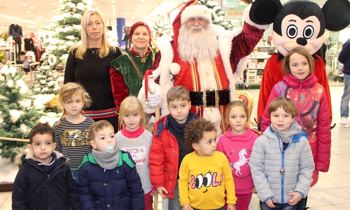 Karina Karger vom Center Management (li.) mit Weihnachtsmann, Wichtel und Weihnachtsmaus sowie einigen der Kinder, die sich eine süße Überraschung abholten. Foto: Alexander Dontscheff