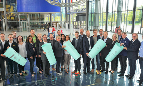 In der Autostadt: Die WMG-Geschäftsführer Jens Hofschröer (9.v.r.) und Dennis Weilmann (11.v.r.), Oberbürgermeister Klaus Mohrs (6.v.r.), Claudius Colsman (Mitglied der Geschäftsführung der Autostadt, 7.v.r.), Thorsten Pitt (Direktor der Autostadt Restaurants operated by Mövenpick, links), Dr. Herbert Engel (WAS, 10.v.r.) und Florian Pachaly (Geschäftsführer der RECUP GmbH, 8.v.r.) gemeinsam mit Vertretern des WMG-Aufsichtsrates und beteiligten Projektpartnern. Foto: WMG Wolfsburg