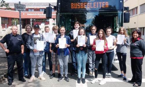 Polizeioberkommissar Thorsten Suppra (links) Betreuungslehrerin Andrea Engelke-Mommert (rechts) rahmen die neuen Schulbusbegleiterinnen und -begleiter ein. Foto: Polizei