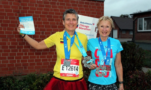 Vor der Denkter Turnhalle zeigen Bettina Börgmann (links) und Cordula Schwarz stolz ihre Medaillen und andere Andenken vom letzten Marathon. Foto:Bernd-Uwe Meyer
