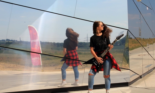 Die Auszubildende Emily Läbe vor dem paläon mit einer der Rockgitarren aus der Verlosung. Fotos: ©paläonGmbH