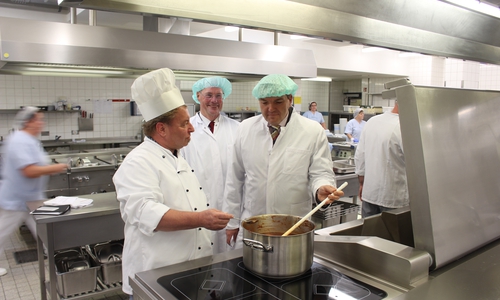 Geschäftsführer Axel Burghardt muss sich beim Kochen der Soße von Küchenchef Georg Hujer beurteilen lassen. Verwaltungsdirektor Klaus Selge lässt lieber Kochen und hält sich im Hintergrund. Foto: Nino Milizia