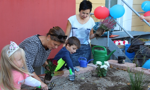 Nach der Begrüßung wurde das frisch angelegte Hochbeet in einer gemeinsamen Aktion bepflanzt. Foto: NEULAND Wohnungsgesellschaft mbH 