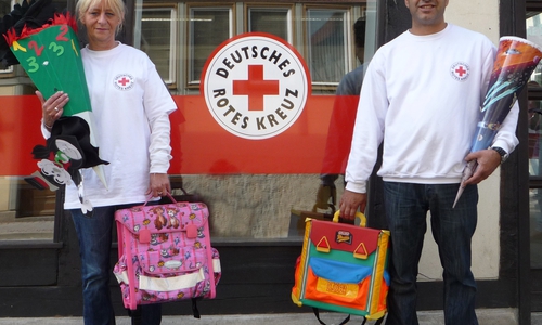 Tafel-Mitarbeiter präsentieren gespendete Schulsachen und - materialien. Foto: DRK
