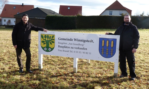 Bürgermeister Michael Waßmann (li.) und der Ortsbeauftragte Mirco Mittag haben im Neubaugebiet ein neues Werbeschild aufgestellt. Foto: privat