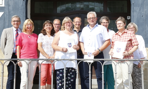 Die drei Dienstjubilare mit Urkunde im Kreise der Gratulanten (v. l.) Claudia Runge, Dirk Fellenberg und Karin Bernhardt. Foto: Stadt Wolfenbüttel