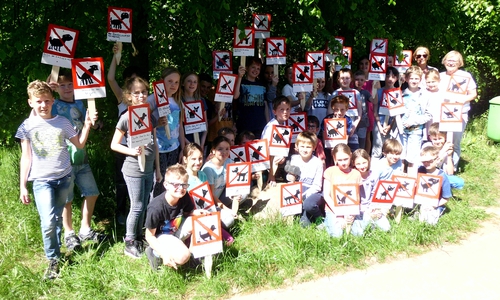 Die Kinder machen mit selbstgemalten Schildern auf das Problem aufmerksam. Foto: Gemeinde Lehre