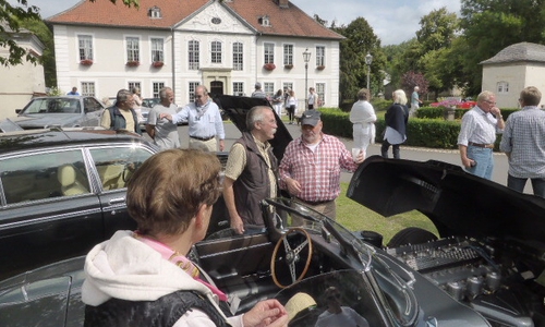 Besucher und Fahrtteilnehmer an den historischen Fahrzeugen vor dem Schloßpotal. Foto: Seniorenbetreuung Schloß Schliestedt