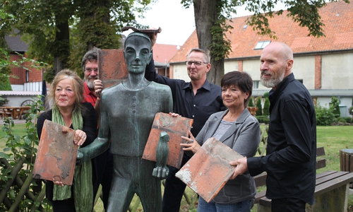 reuen sich auf das Dachziegel-Fest (v.l.n.r.): Charlotte Papendorf (Museumsleiterin), Prof. Alexander Schwarz (ehrenamtlicher Mitarbeiter des Museums), Till Eulenspiegel, Dirk Neumann (Fachbereichsleiter), Regina Bollmeier (Samtgemeindebürgermeisterin) und Henry Frommert (Projektmanager der Umgestaltungsmaßnahmen) und das alte Dach im Hintergrund Foto: Eulenspiegel Museum Dachziegelfest Foto: Eulenspiegel-Museum

 