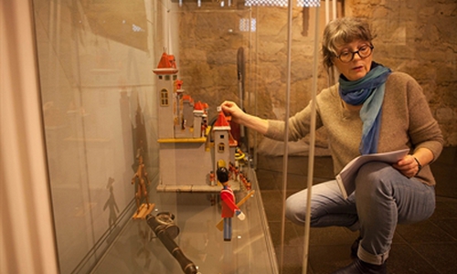 Doris Schulz-Wahle beim Aufbau der Ausstellung "Kinderträume aus buntem Holz". Foto: Stadtmuseum Schloss Wolfsburg/Peter Riewaldt